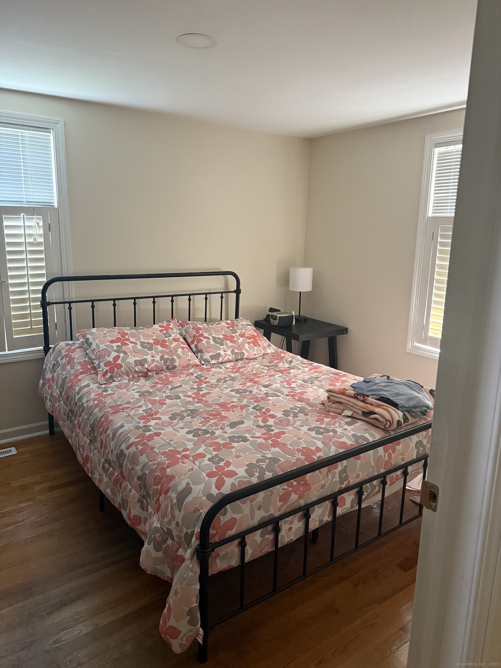 1347 East Main Street Meriden, CT 06450 - Photo 4 of 4 a bed sitting in a bedroom next to a window with a table and chair