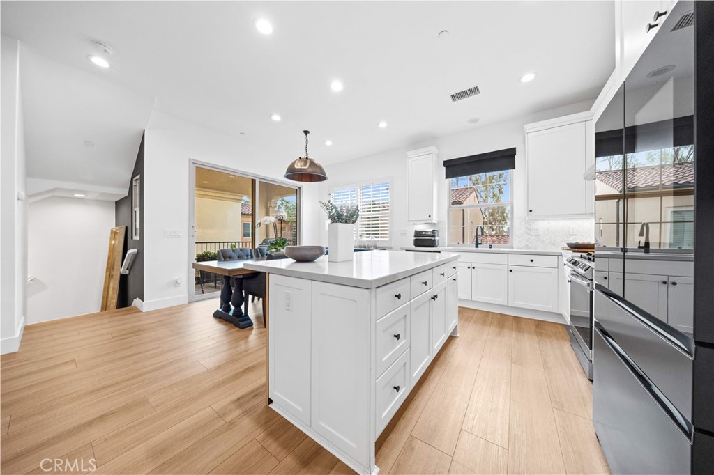 89 Kestrel Irvine, CA 92618 - Photo 13 of 45 a large kitchen with stainless steel appliances kitchen island granite countertop a large counter top a sink a stove and a refrigerator