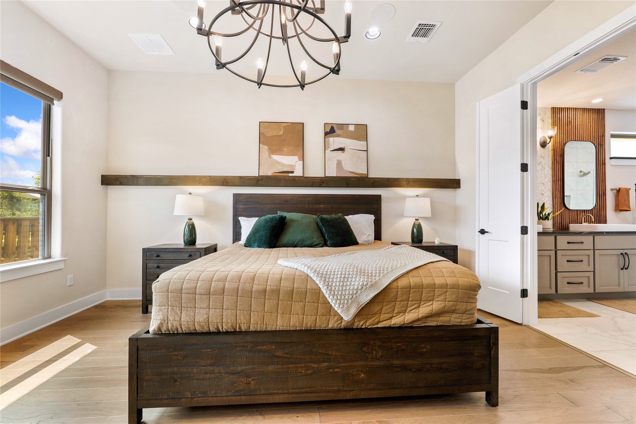2408 Nate's Place Georgetown, TX 78633 - Photo 18 of 40 A tranquil primary bedroom with light wood flooring and an attached private bathroom.