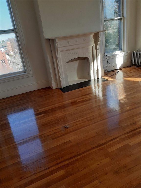 112 School Street Clinton, MA 01510 - Photo 11 of 20 a view of empty room with wooden floor and fireplace