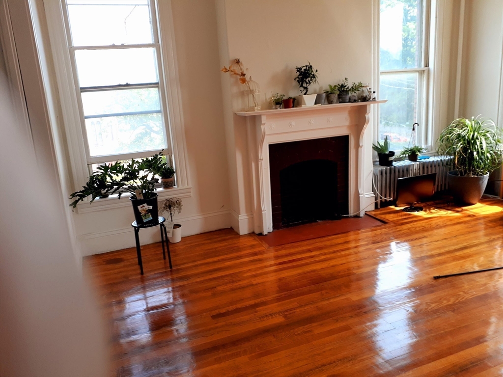 112 School Street Clinton, MA 01510 - Photo 7 of 20 a living room with a fireplace furniture and a potted plant