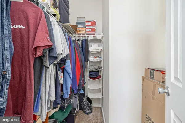 a view of walk in closet with clothes
