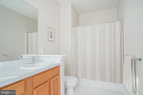 a bathroom with a granite countertop sink a toilet and a mirror