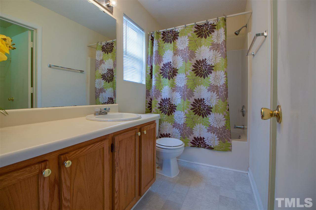 2905 Oneida Court Raleigh, NC 27610 - Photo 13 of 21 a bathroom with a granite countertop sink a toilet and shower