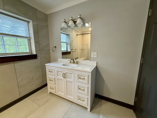a bathroom with a double vanity sink mirror and window