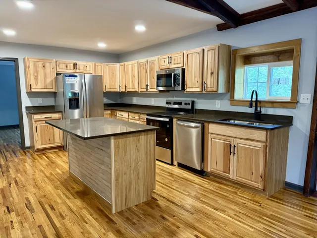 a kitchen with stainless steel appliances granite countertop a sink stove and refrigerator
