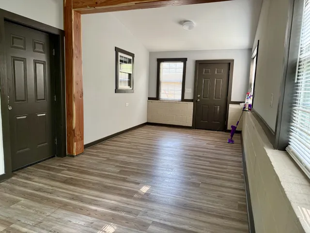 a view of a livingroom with wooden floor and stairs