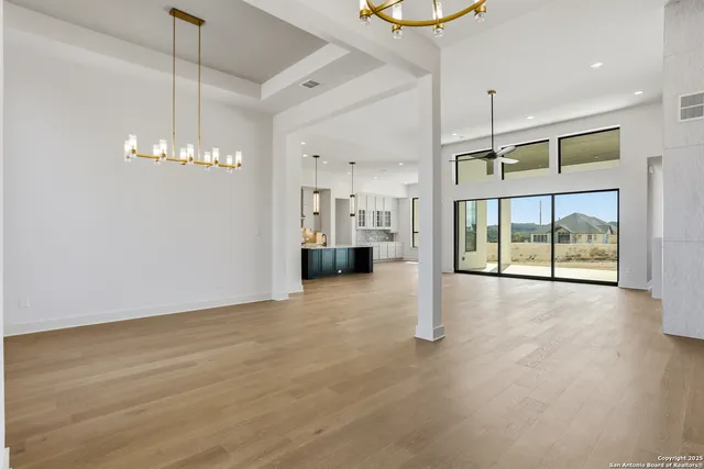 a view of an empty room with a fireplace and chandelier