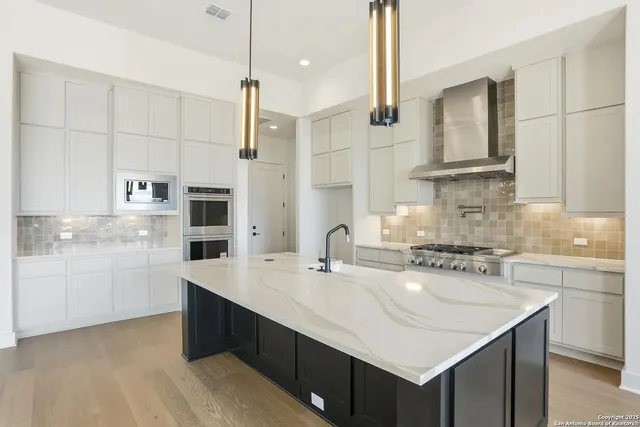 a kitchen with stainless steel appliances a sink stove and refrigerator