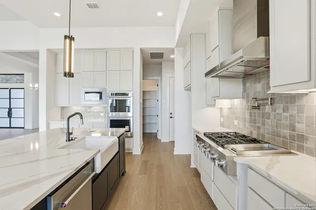 a kitchen with stainless steel appliances a sink stove and cabinets