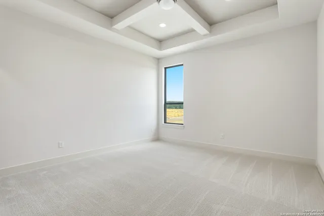 an empty room with windows and chandelier fan
