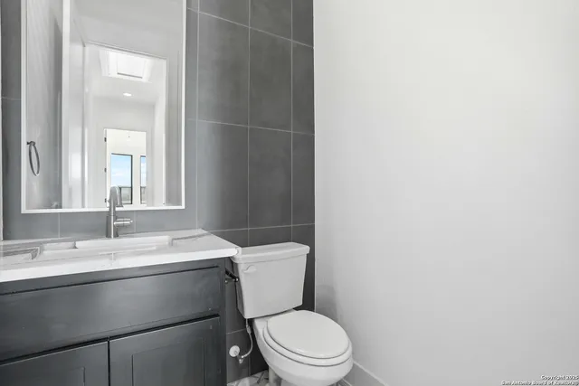 a bathroom with a toilet a sink and mirror