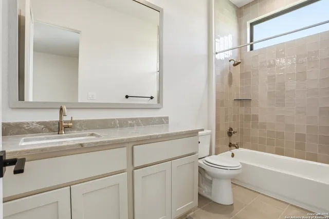 a bathroom with a granite countertop toilet sink and a bathtub