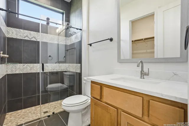 a bathroom with a sink a toilet and mirror