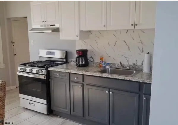 a kitchen with granite countertop white cabinets and white appliances