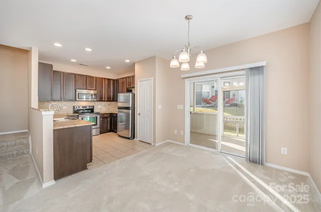 a kitchen with stainless steel appliances granite countertop a refrigerator and a sink