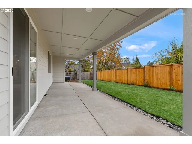 a view of backyard with potted plants and wooden fence