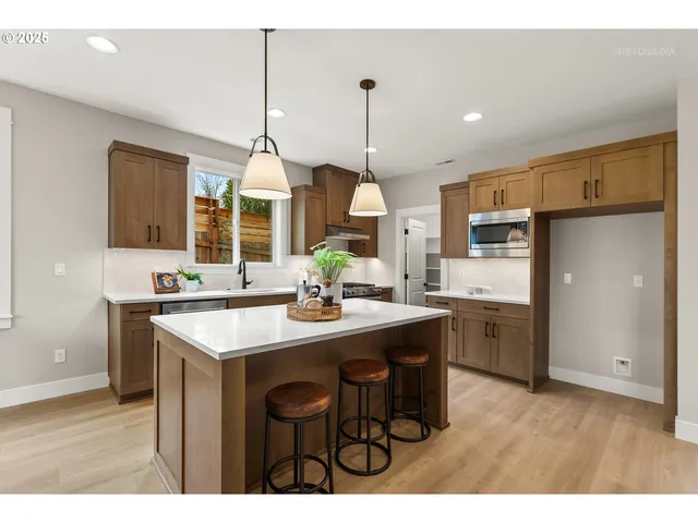 a kitchen with kitchen island a sink stove and refrigerator
