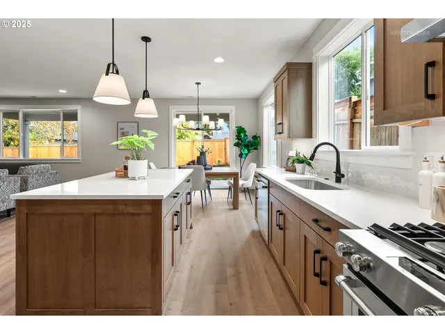 a kitchen with kitchen island granite countertop a sink appliances and cabinets