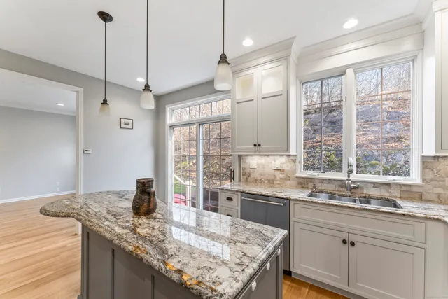 a kitchen with granite countertop a sink a counter space appliances and cabinets