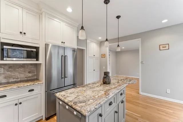 a kitchen with stainless steel appliances granite countertop wooden cabinets a refrigerator and a stove