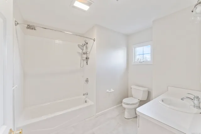 a bathroom with a bathtub shower sink vanity and toilet
