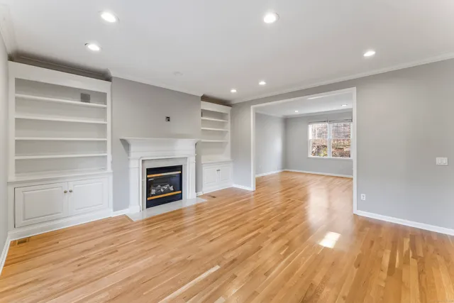 a view of empty room with a fireplace and wooden floor