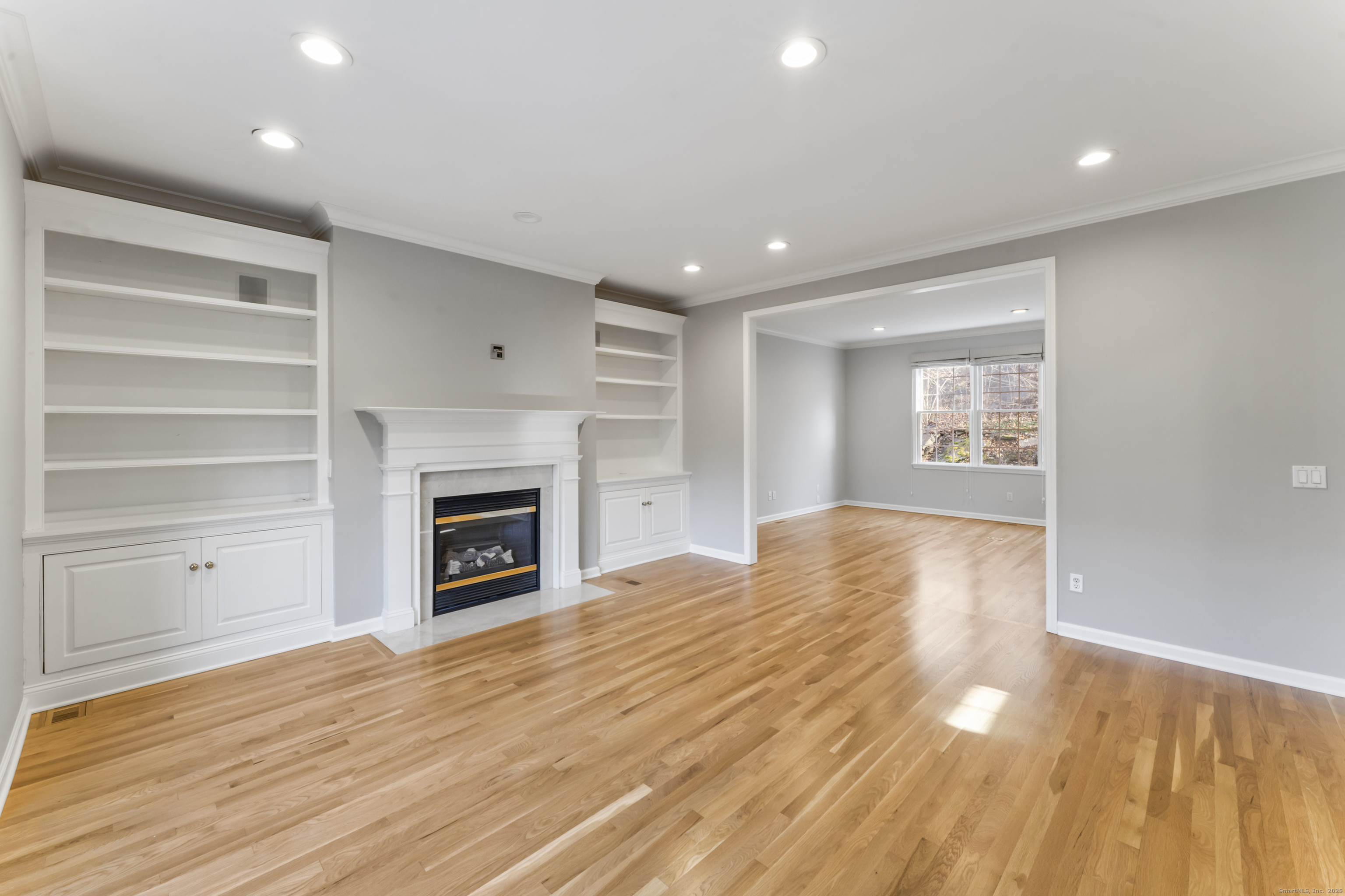 4 Woods Way New Fairfield, CT 06812 - Photo 6 of 39 a view of empty room with a fireplace and wooden floor