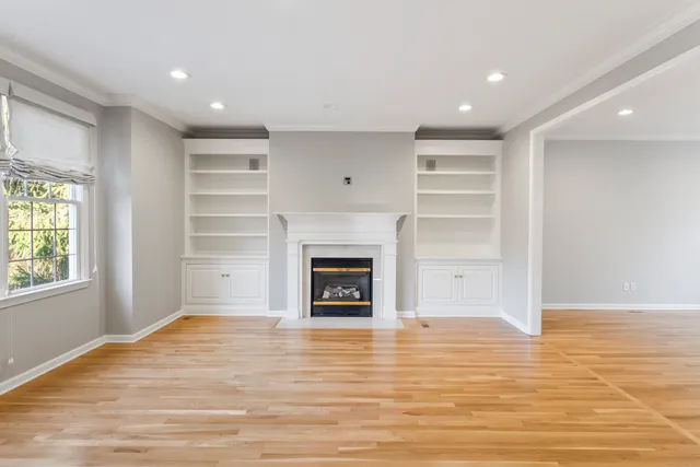 a view of an empty room with a window and fireplace