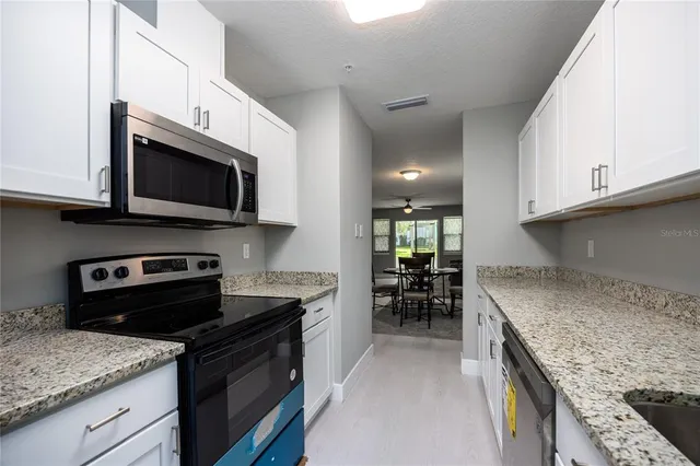 a kitchen with stainless steel appliances granite countertop a sink stove microwave and cabinets