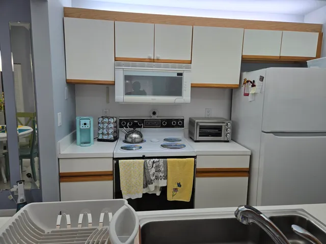 a kitchen with a refrigerator and a stove top oven