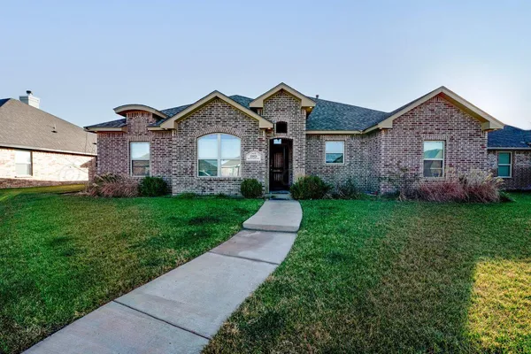a front view of house with yard and green space