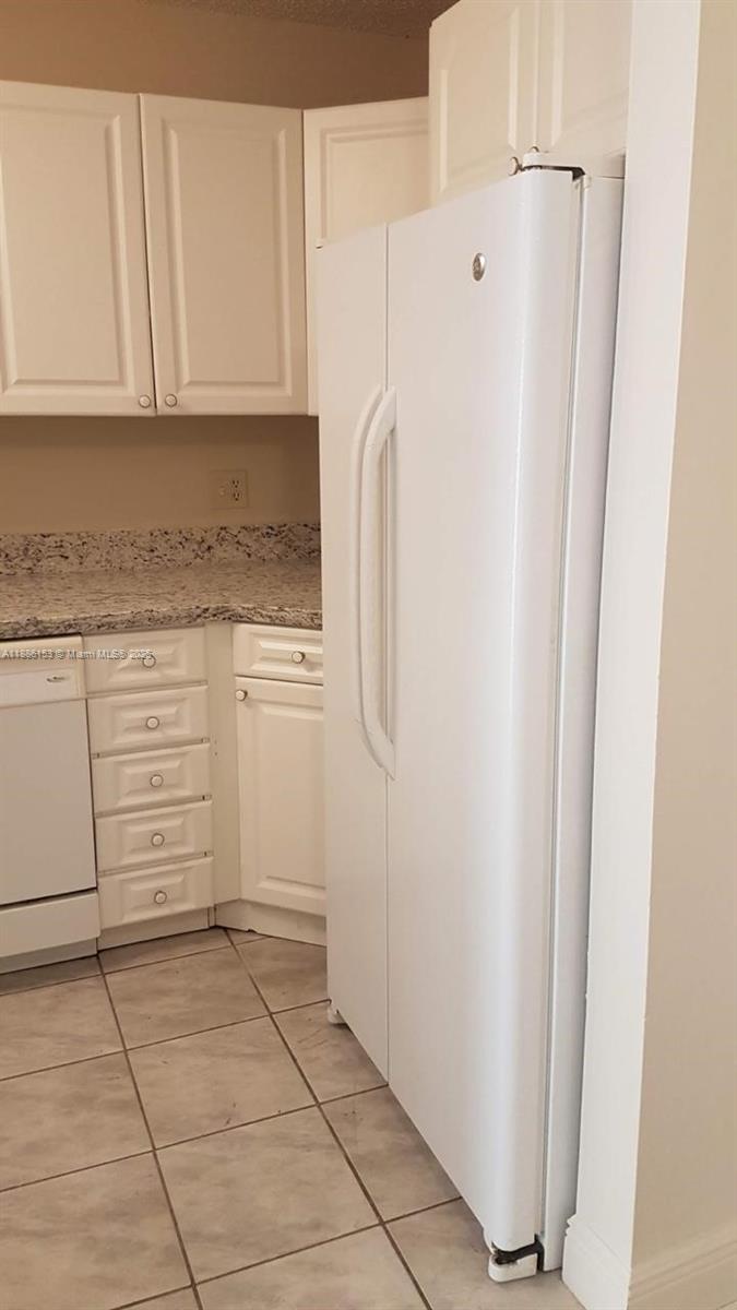 11386 Royal Palm Boulevard, Unit 11386 Coral Springs, FL 33065 - Photo 3 of 10 a kitchen with a refrigerator sink and cabinets