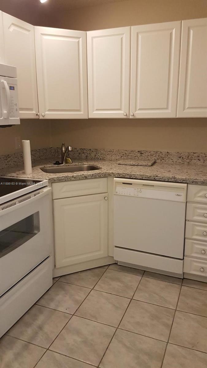 11386 Royal Palm Boulevard, Unit 11386 Coral Springs, FL 33065 - Photo 4 of 10 a kitchen with granite countertop cabinets stainless steel appliances and a sink