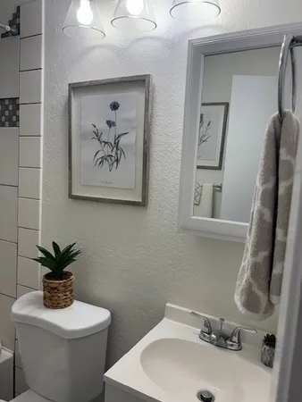 a bathroom with a toilet sink and mirror