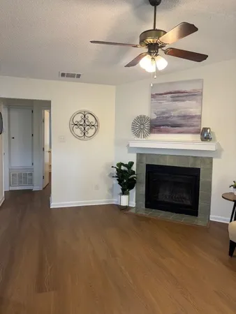 a view of a livingroom with a fireplace a chandelier and windows