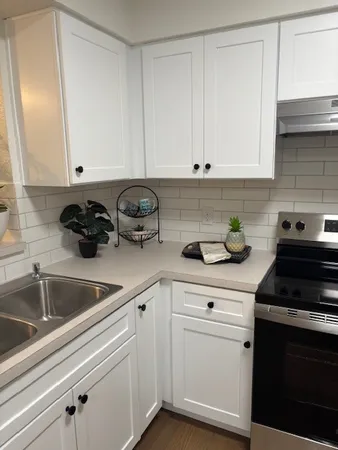 a kitchen with white cabinets and white appliances
