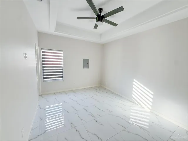 an empty room with windows and fan