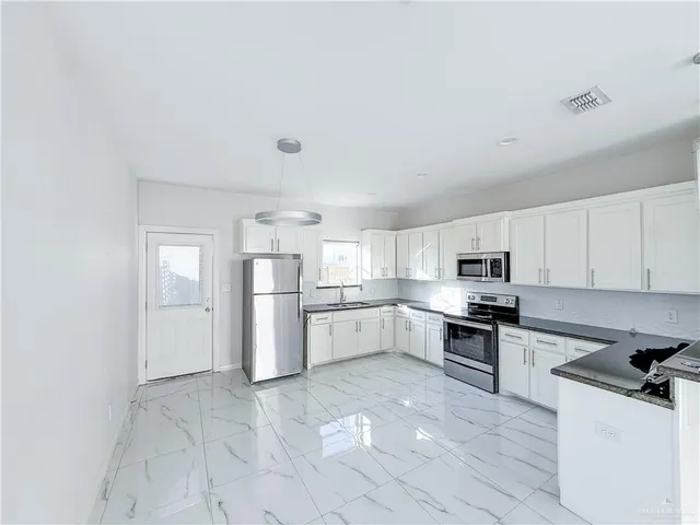 a kitchen with a sink a refrigerator and cabinets