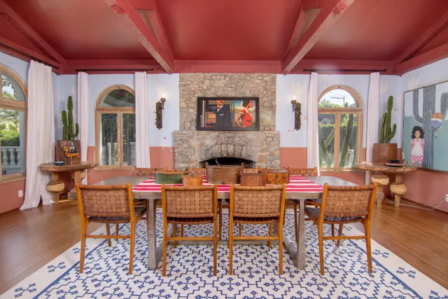 a large white kitchen with stainless steel appliances granite countertop a stove a sink a refrigerator and white cabinets with wooden floor