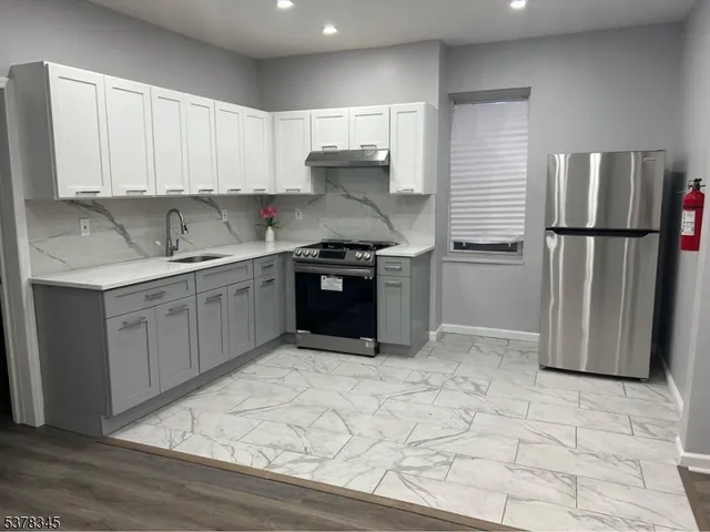 a kitchen with stainless steel appliances granite countertop a stove a refrigerator and a sink