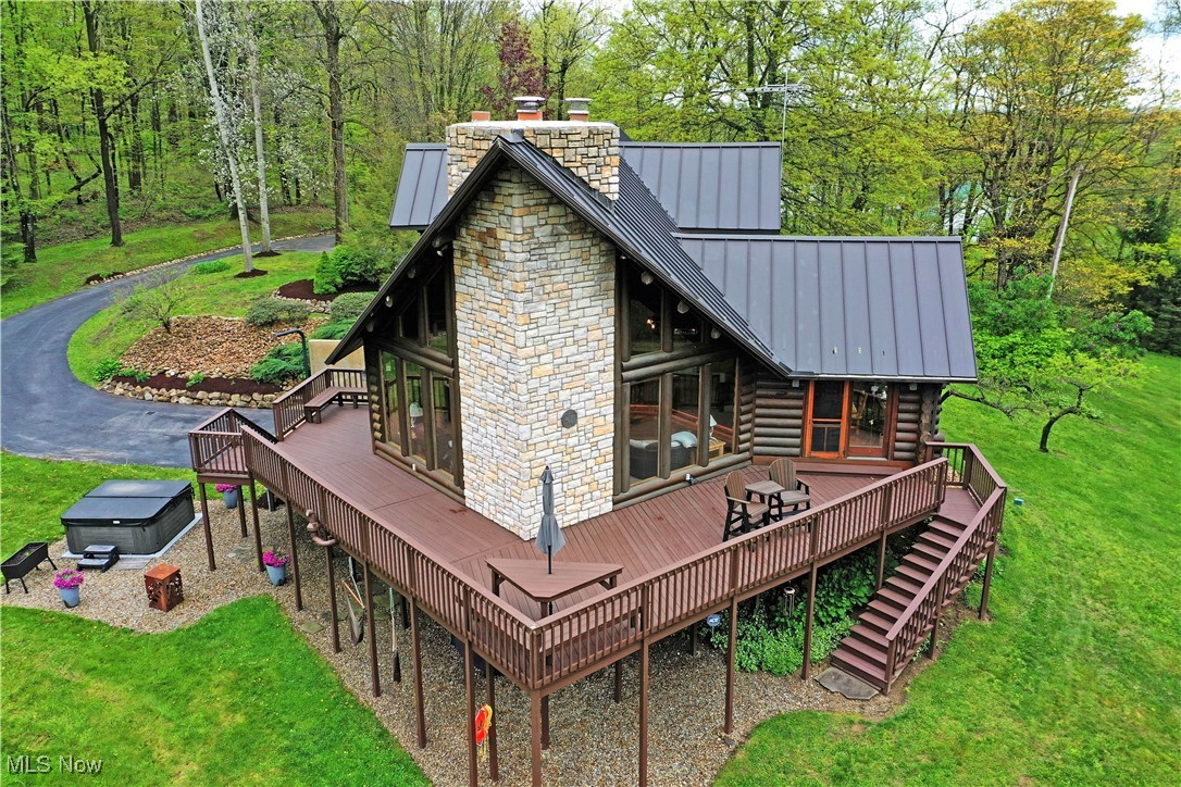 18102 Owen Road Middlefield, OH 44062 - Photo 3 of 50 Rear view of house with a standing seam roof, a chimney, a wooden deck, and log siding