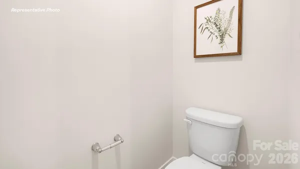 a white toilet sitting next to a white wall