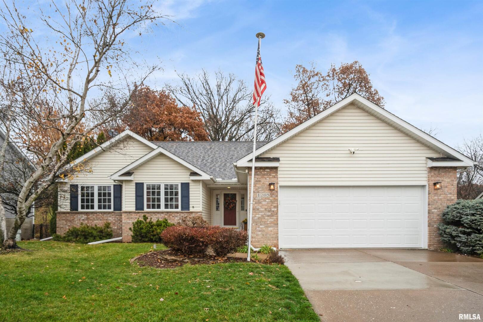 a front view of a house with a garden and plants