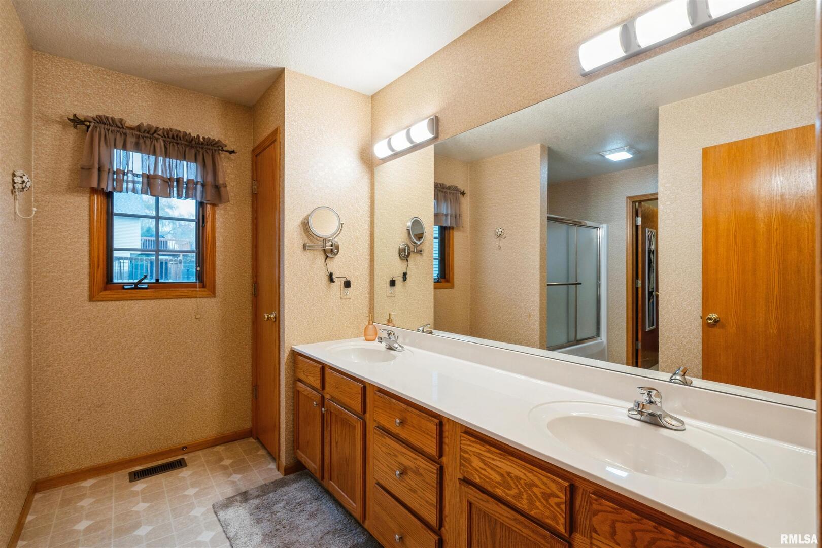 1205 28th Avenue Silvis, IL 61282 - Photo 11 of 24 a spacious bathroom with double vanity sink a mirror and a shower