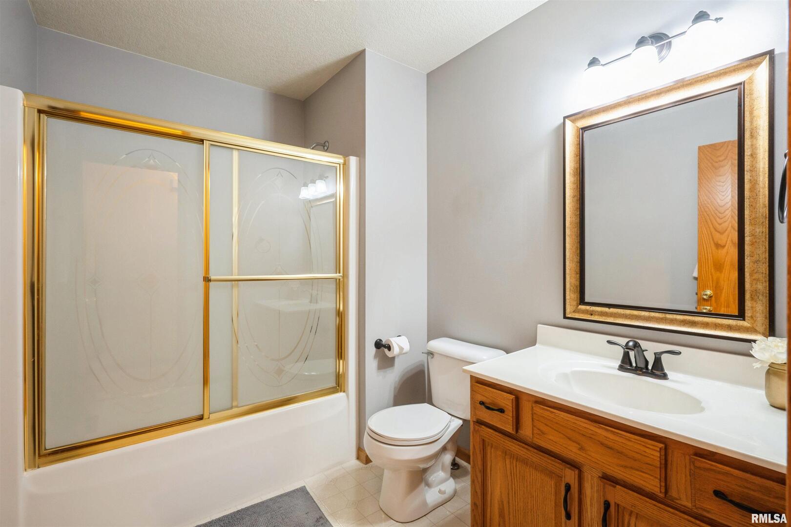 1205 28th Avenue Silvis, IL 61282 - Photo 14 of 24 a bathroom with a granite countertop toilet sink and a mirror