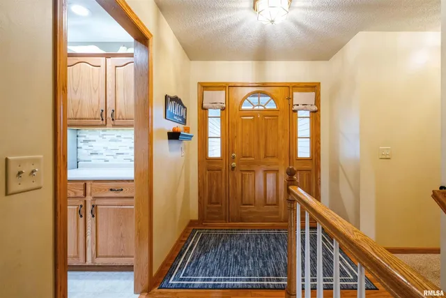 a view of a hallway with wooden floor and a chandelier