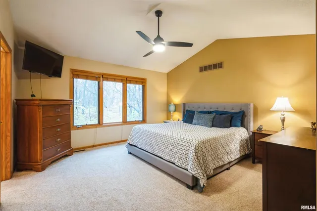 a bedroom with a bed dresser and a flat tv screen