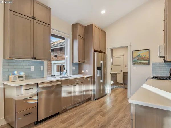 a kitchen with stainless steel appliances a sink cabinets and wooden floor