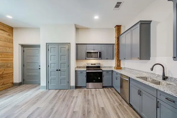 a kitchen with stainless steel appliances granite countertop a sink stove and refrigerator
